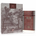 Experience Afnan Oud Rising 2.8 oz EDP. Elegant rose gold bottle with intricate patterns, grey sides, beside its unique vintage-illustrated box.