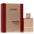 Luxurious Al Haramain Amber Oud Rouge 2 oz EDP. Sleek rose gold bottle with red liquid, alongside its elegant red and metallic gold box.