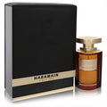 Al Haramain Portfolio Portrait Sandal EDP: Rich amber fragrance in a sophisticated glass bottle with gold cap, beside its elegant black and gold box.