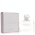 Luxurious Estee Lauder Beautiful Magnolia EDP. Elegant blush pink glass bottle with clear cap, beside its matching metallic-edged box.