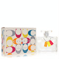 Coach Signature Color 3.3 oz EDP spray. Clear glass bottle with vibrant orange, yellow, red charm tags, next to its iconic C-logo box.