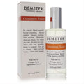 Demeter Cinnamon Toast 4 oz cologne spray, clear glass bottle with silver cap, alongside its elegant white and orange-brown branded box.