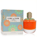 Elie Saab Girl of Now Lovely 3 oz EDP. Vibrant orange perfume bottle with green floral collar, beside its elegant blue and gold floral box.