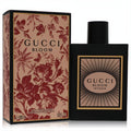 Sleek black Gucci Bloom Intense 3.3 oz EDP bottle with radiant label, beside its ornate floral-patterned box.