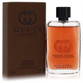Gucci Guilty Absolute 1.6 oz men's EDP. Clear bottle with warm amber liquid, black cap, and brown box featuring the iconic GG logo.