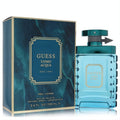 Guess Uomo Acqua 3.4 oz men's Eau De Toilette in a stylish aqua glass bottle with textured sides, teal cap, and elegant marbled box.