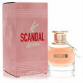 Experience Scandal! Jean Paul Gaultier 1 oz EDP spray: elegant pink box, clear bottle with peachy liquid, gold cap, and signature leg charm.