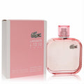 Chic Lacoste L.12.12 Rose Sparkling 3.3 oz EDT. Features a stylish pink bottle with textured glass and iconic crocodile logo, alongside its matching box.
