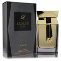 Lattafa Rave Luxure 3.4 oz men's EDP. Striking gold bottle with a black ribbon, "L" charm, and sophisticated black box.