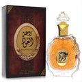Captivating Lattafa Rouat Al Oud unisex EDP, 3.4 oz. Ornate clear glass bottle with amber liquid, gold accents, and a luxurious maroon box.