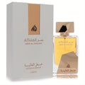 Lattafa Ser Al Malika 3.4 oz women's EDP. Elegant clear glass bottle with golden liquid, metallic gold cap, and luxurious white and gold box.