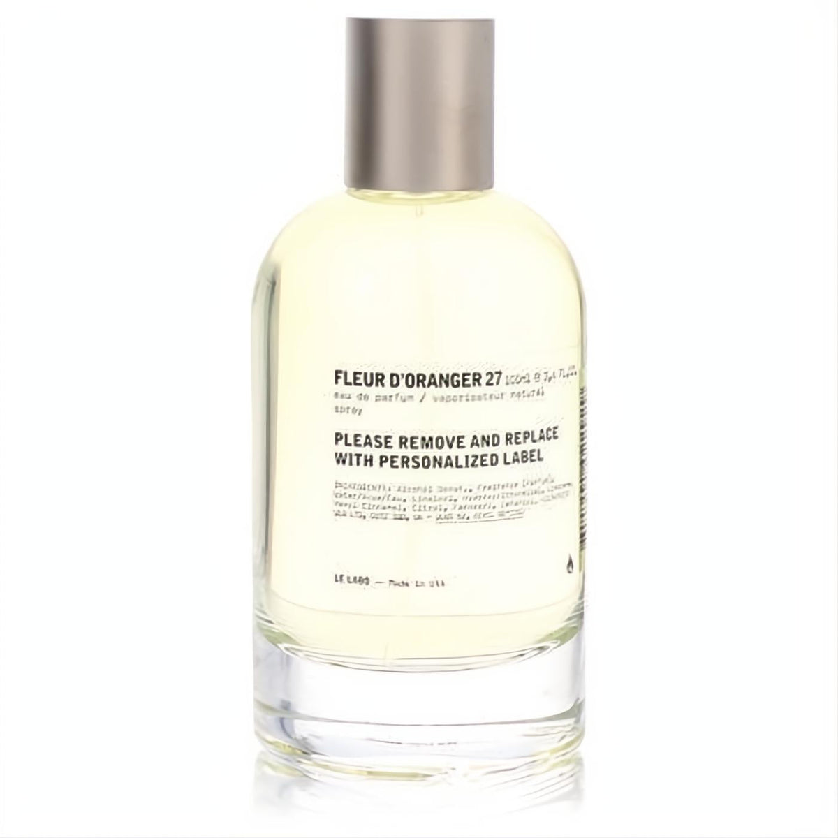 Elegant Le Labo Fleur D'oranger 27 Eau De Parfum spray. Clear glass bottle with light yellow fragrance and a sleek silver cap.