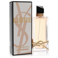 Indulge in Libre by YSL 3 oz Eau De Toilette. Clear bottle with iconic gold logo, elegant black cap, and amber liquid, beside its stylish box.