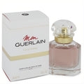 Mon Guerlain 1 oz Eau De Parfum. Elegant faceted glass bottle with light pink liquid, gold collar, and clear cap, beside its white and gold box.