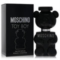 Moschino Toy Boy 1 oz Eau De Parfum: a bold black teddy bear bottle with silver details, beside its matching sleek black box.