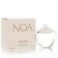 Noa by Cacharel 3.4 oz EDT spray. Elegant clear spherical bottle with white cap, signature pearl, and green accent, beside its beige box.