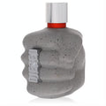 Diesel Only the Brave Street men's cologne bottle, a bold grey speckled concrete fist with silver cap and red band.