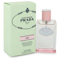 Prada Infusion De Rose 3.4 oz EDP: Elegant clear glass bottle with pink liquid, silver logo, and matching cap, next to its pale green box.