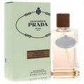 Prada Infusion De Vanille 3.3 oz EDP. Clear glass bottle with warm peach liquid, brown cap, and elegant light green box.