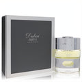 The Spirit of Dubai Abraj 1.7 oz Eau De Parfum. Elegant bottle with pale yellow fragrance, ornate silver cap, and luxurious dark grey box.