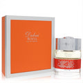 Luxurious The Spirit of Dubai Roeya 1.7 oz unisex EDP. Elegant bottle with sparkling red crystals, ornate silver cap, and vibrant orange box.